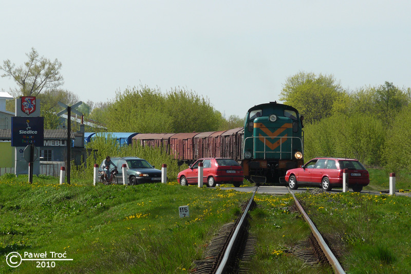 Rok 2010. SM42-1009 podstawia skład wagonów krytych na bocznicę w Strzale. Na pierwszym planie przejazd kolejowy w ciągu ul. Sokołowskiej.